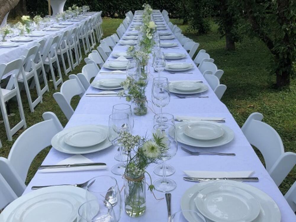 Lange gedekte feesttafel in de tuin, verzorgd door Partyverhuur Leerdam